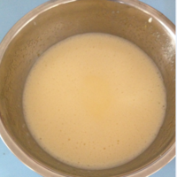 全蛋加绵白糖用打蛋器搅匀，加人葵花籽油搅拌均匀，再加人牛奶，继续搅拌呈均匀的液体状。
