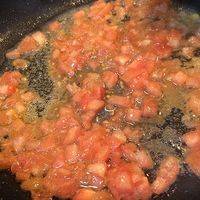 热锅放入橄榄油，再加入番茄碎，先翻炒一会，煸炒出番茄汁。