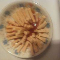 将薯条放在小盘边上,在中间倒上番茄酱。