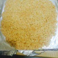 将拌匀的卜卜米，放到锡纸上，把卜卜米均匀地压成米饼