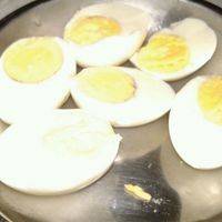 水煮蛋剥壳切半。