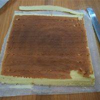 将蛋糕翻转，斜切去近身端和远端的蛋糕边，并以2cm的间隔划上浅痕。