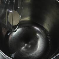 将水倒入和面桶中，加入酵母搅拌均匀