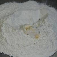面粉过筛后与白糖混合，将40克黄油室温软化后加入面粉中，倒入水