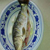 　　2、将天麻片放入鱼头和鱼腹内，再将鱼放入搪瓷盆内，加葱头、姜丝。