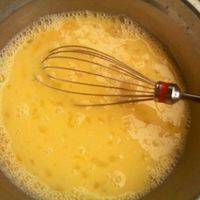 把鸡蛋磕进盘子里，放入白糖，凉开水一起搅匀