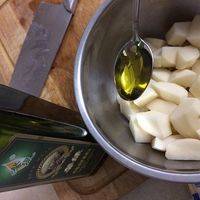 土豆块放入大碗中，加入橄榄油拌匀