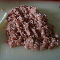 羊肉剁碎，剁成粗肉馅儿，如果肉太瘦，可加一些羊板油一起剁